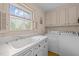Functional laundry room with sink, white cabinets, included washer and dryer, and natural light at 5130 Guess Rd, Durham, NC 27712