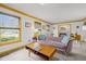 Bright living room with a modern sofa, large windows, and an adjacent dining area at 5130 Guess Rd, Durham, NC 27712