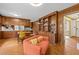 Inviting living area with wood paneling, built-in bookcase, and view into the kitchen at 5130 Guess Rd, Durham, NC 27712