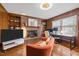Cozy living room with a brick fireplace, built-in shelving, and hardwood floors at 5130 Guess Rd, Durham, NC 27712