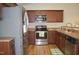 This kitchen features stainless steel appliances, brown cabinets, and wood-look floors at 536 Dearing Dr, Haw River, NC 27258