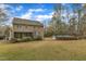 Large backyard with mature trees and grass featuring a swimming pool, screened porch, and wood fence at 5521 Erinvale Ct, Holly Springs, NC 27540