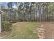 Expansive backyard with mature trees, grass, and a shed for storage or hobbies at 5521 Erinvale Ct, Holly Springs, NC 27540