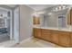 Bathroom featuring a dual sink vanity with wood cabinets and a large mirror at 5521 Erinvale Ct, Holly Springs, NC 27540