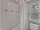 Bright bathroom with tile surround, polka dot shower curtain, and window at 5521 Erinvale Ct, Holly Springs, NC 27540