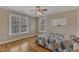 Bedroom features natural light, ceiling fan, hardwood floor, and a whiteboard at 5521 Erinvale Ct, Holly Springs, NC 27540