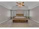 Bedroom features a natural wood bed set, ceiling fan, and lots of natural light at 5521 Erinvale Ct, Holly Springs, NC 27540