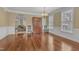 Dining room boasting hardwood floors, large windows, and direct view into the living room at 5521 Erinvale Ct, Holly Springs, NC 27540