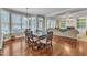 Bright dining area featuring large windows and wood floors, next to the living room at 5521 Erinvale Ct, Holly Springs, NC 27540