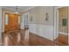 Entryway featuring hardwood floors, wainscoting, and a solid wood door with sidelight windows at 5521 Erinvale Ct, Holly Springs, NC 27540