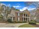 Side view of a brick home with a two story porch, a driveway, and lush landscaping at 5521 Erinvale Ct, Holly Springs, NC 27540