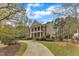 Brick home with a two-story porch, a curved driveway, lush landscaping, and blue sky at 5521 Erinvale Ct, Holly Springs, NC 27540