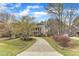 Attractive brick home with a long driveway lined with trees and beautiful landscaping at 5521 Erinvale Ct, Holly Springs, NC 27540