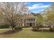 Beautiful two-story brick home with a manicured lawn and mature trees creating curb appeal at 5521 Erinvale Ct, Holly Springs, NC 27540