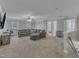 Spacious living room with a large sectional sofa and neutral carpeting at 5521 Erinvale Ct, Holly Springs, NC 27540