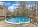 Backyard features a refreshing above-ground pool with a wooden deck for lounging at 5521 Erinvale Ct, Holly Springs, NC 27540