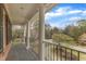 Charming outdoor porch featuring classic columns and wrought iron railing with a view to the neighborhood at 5521 Erinvale Ct, Holly Springs, NC 27540