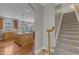 Hallway with a staircase, leading to a kitchen with a large island at 5521 Erinvale Ct, Holly Springs, NC 27540