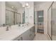 Bright primary bathroom with double vanity sinks, herringbone shower, and open bedroom view at 607 N Queen St, Durham, NC 27701