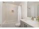 Bright bathroom features a shower-over-tub, gray vanity, and white herringbone-patterned tile at 607 N Queen St, Durham, NC 27701