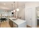 Modern kitchen with quartz island, stainless steel appliances, and open access to adjacent rooms at 607 N Queen St, Durham, NC 27701