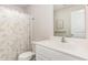 Bright bathroom with a clean white vanity, a toilet, and a shower with a leafy shower curtain at 733 Frosty Way, Zebulon, NC 27597