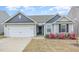 Charming single Gathering home showcasing a manicured lawn and attached two car garage at 733 Frosty Way, Zebulon, NC 27597