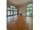 Spacious living room with a fireplace, large windows offering lake views, and gleaming hardwood floors at 737 Crabtree Crossing Pkwy, Cary, NC 27513