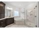 Bright bathroom with soaking tub, walk-in shower with glass enclosure, and white tile at 8117 Fergus Ct, Wake Forest, NC 27587