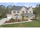 Striking brick home boasts a three-car garage, covered front porch, and meticulously landscaped grounds at 8117 Fergus Ct, Wake Forest, NC 27587