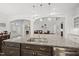 A granite island with a stainless steel sink and dark wood cabinetry in a white kitchen at 8117 Fergus Ct, Wake Forest, NC 27587