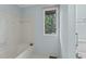 Bright bathroom featuring a tub and shower combination, window, and neutral color palette at 8805 Leesville Rd, Raleigh, NC 27613