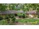 Charming stone home featuring a unique roofline and lush landscaping at 8805 Leesville Rd, Raleigh, NC 27613