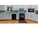 Modern kitchen featuring sleek black appliances, white cabinets, and a stylish blue backsplash at 8805 Leesville Rd, Raleigh, NC 27613