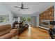 Inviting living room with hardwood floors, ceiling fan, stone fireplace, and access to the backyard at 8805 Leesville Rd, Raleigh, NC 27613