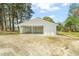 Exterior view of a detached two-car garage with white siding and concrete floor at 8917 Fowler Rd, Zebulon, NC 27597