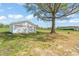 Spacious two-door garage with a white exterior, set amidst a large yard and a mature tree at 8917 Fowler Rd, Zebulon, NC 27597
