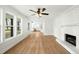 Bright living room with brick fireplace and view to kitchen with new flooring at 8917 Fowler Rd, Zebulon, NC 27597