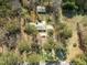 An aerial view of the property with a detached garage, mature trees, and a long driveway at 906 Perry Rd, Zebulon, NC 27597