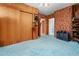 Retro bedroom featuring blue carpet, wood paneling, and a closet with sliding doors at 906 Perry Rd, Zebulon, NC 27597
