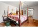 Primary bedroom with hardwood floors, four-poster bed, and an ornate quilt at 906 Perry Rd, Zebulon, NC 27597