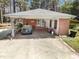 View of the carport featuring a brick facade, covered parking, and a 'welcome' sign at 906 Perry Rd, Zebulon, NC 27597