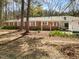 Charming brick home featuring mature trees, bright white trim, and a welcoming covered porch at 906 Perry Rd, Zebulon, NC 27597