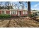 Charming single-story brick house featuring a covered carport and mature trees in a spacious front yard at 906 Perry Rd, Zebulon, NC 27597