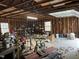 Spacious garage with exposed wood rafters and shelving filled with tools and equipment at 906 Perry Rd, Zebulon, NC 27597