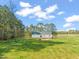 A home's backyard offers a spacious lawn and views of the surrounding wooded landscape at 9550 Stallings Road Rd, Spring Hope, NC 27882