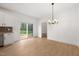 Bright dining area featuring wood flooring, modern chandelier, and sliding glass doors to the backyard at 9550 Stallings Road Rd, Spring Hope, NC 27882