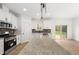 Modern kitchen featuring a granite island, stainless appliances, tile backsplash, and wood flooring at 9550 Stallings Road Rd, Spring Hope, NC 27882