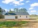 A home's rear exterior features sliding glass doors and simple landscaping against a backdrop of trees at 9550 Stallings Road Rd, Spring Hope, NC 27882