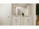 Bathroom showcasing a double vanity with white cabinets and a framed mirror above at 1002 Sora Way, Durham, NC 27703